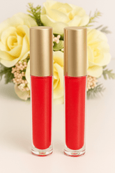 Fleurish Beauty Handmade Lip Gloss in vibrant red, showcasing elegance and shine, surrounded by soft yellow roses.